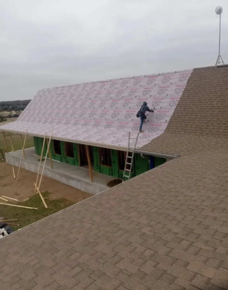 Worker preparing underlayment for a metal roof installation in Green Valley
